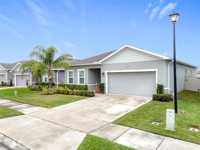 single story home with a garage, driveway, a front lawn, and stucco siding