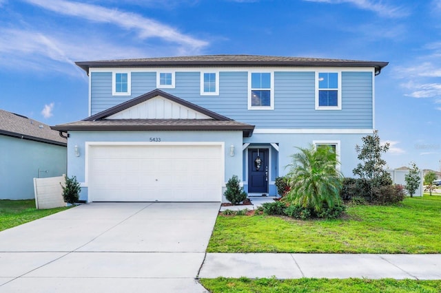 traditional-style home featuring driveway, a garage, and a front lawn