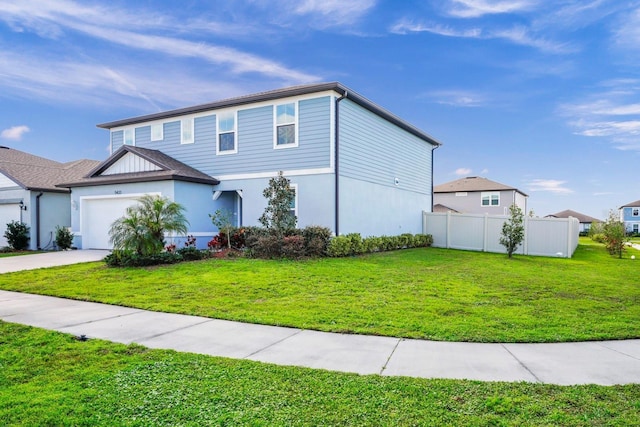 view of front of home with concrete driveway, a front lawn, an attached garage, and fence