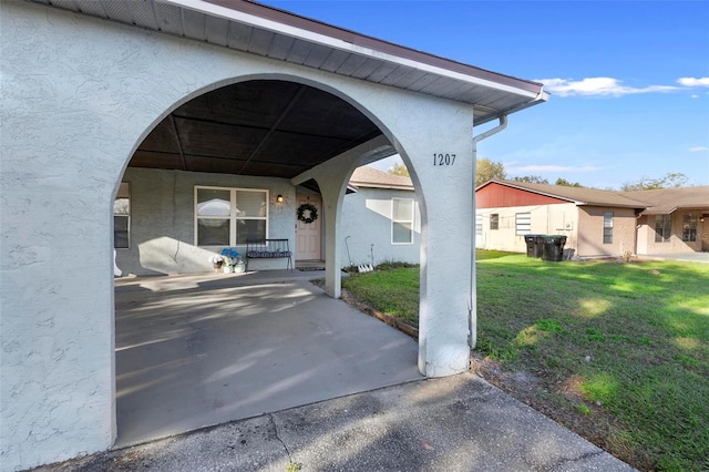 property entrance with a porch, a lawn, and stucco siding