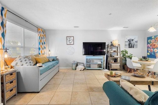 living room with visible vents, a textured ceiling, baseboards, and light tile patterned floors