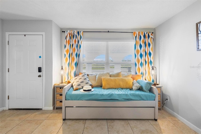 tiled bedroom with a textured ceiling and baseboards