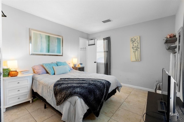 bedroom featuring visible vents, baseboards, and light tile patterned floors