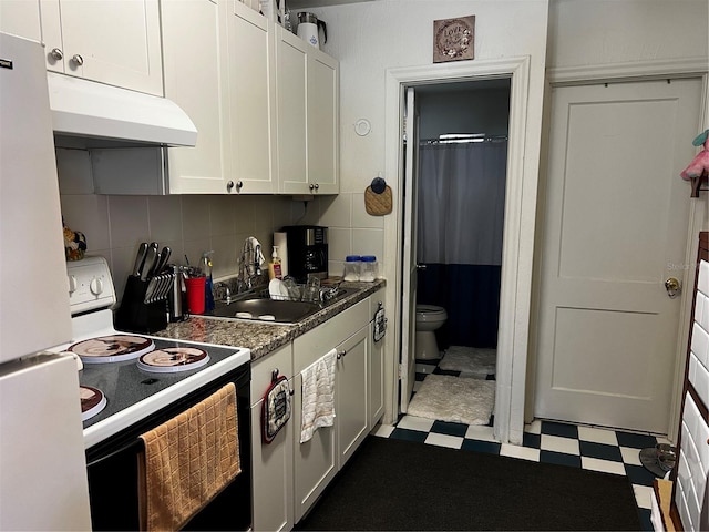 kitchen featuring electric stove, freestanding refrigerator, a sink, under cabinet range hood, and tile patterned floors