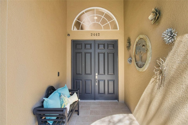 doorway to property featuring stucco siding