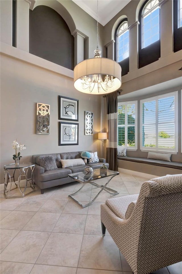 living room featuring light tile patterned flooring, a towering ceiling, and an inviting chandelier