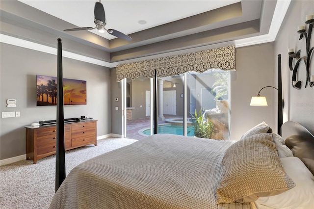 bedroom featuring light carpet, baseboards, arched walkways, ceiling fan, and a tray ceiling