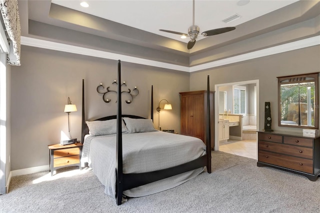 bedroom featuring a tray ceiling, carpet, visible vents, and baseboards