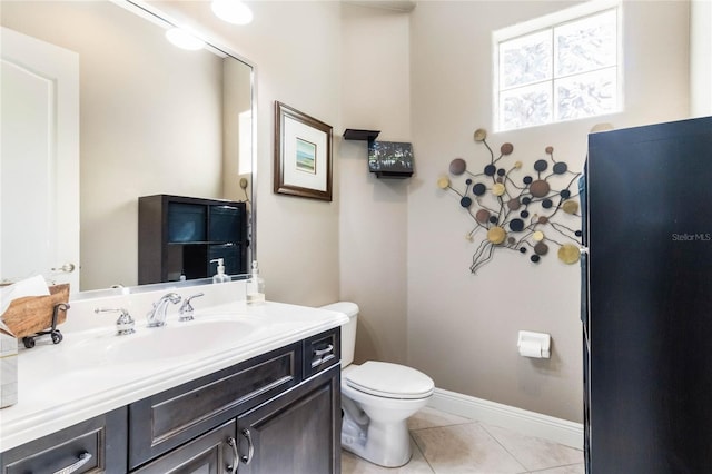 bathroom featuring vanity, tile patterned flooring, toilet, and baseboards