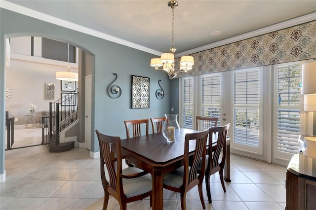 dining room with baseboards, arched walkways, stairway, ornamental molding, and light tile patterned flooring