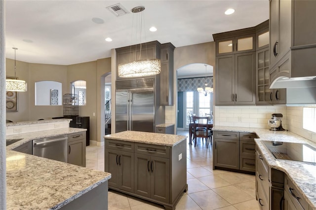 kitchen featuring appliances with stainless steel finishes, arched walkways, visible vents, and tasteful backsplash