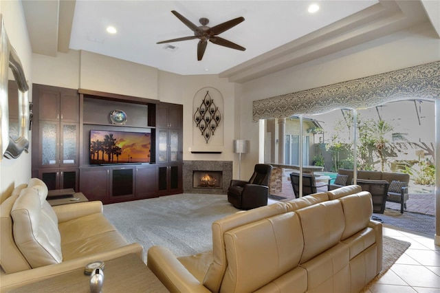 living area with light tile patterned floors, recessed lighting, visible vents, ceiling fan, and a lit fireplace