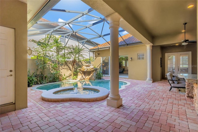 view of patio / terrace featuring ceiling fan, glass enclosure, french doors, and a pool with connected hot tub