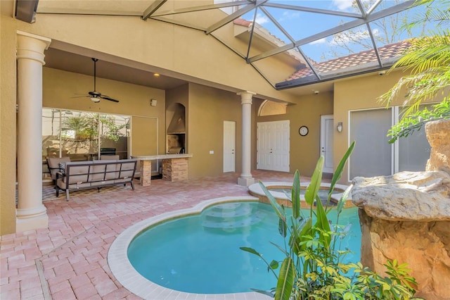 view of pool featuring a patio, an outdoor kitchen, an outdoor hangout area, a ceiling fan, and a lanai