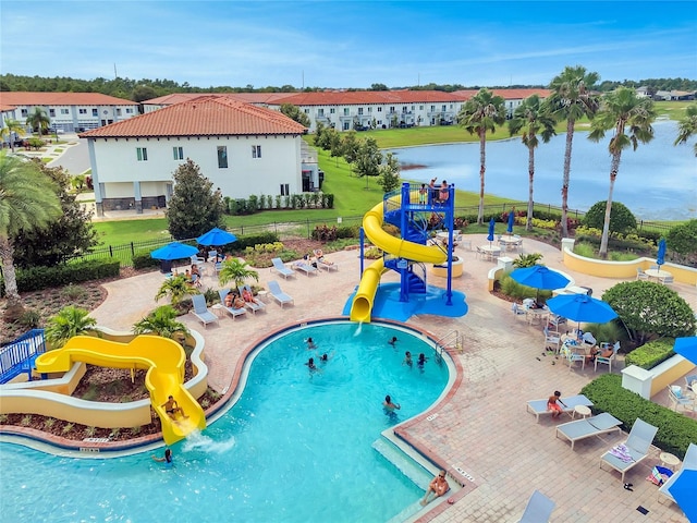 pool featuring playground community, a water play area, a water slide, and a patio