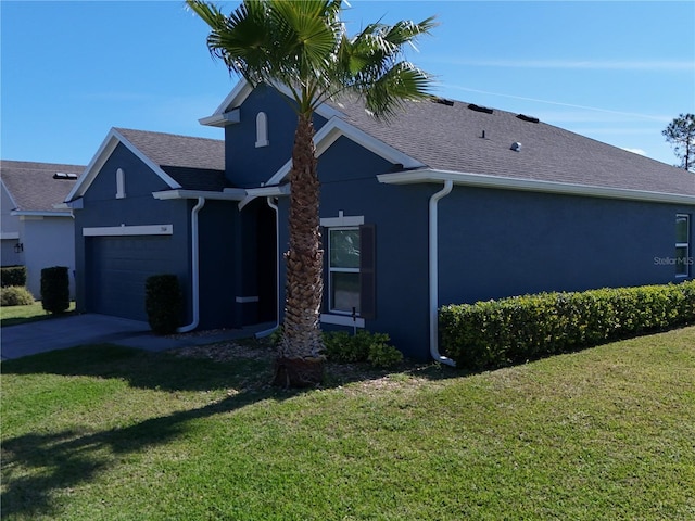 single story home featuring a garage, a front yard, and stucco siding