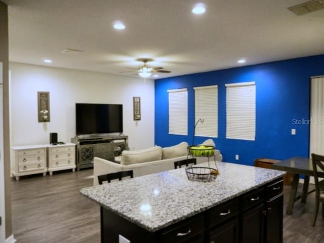 kitchen with a kitchen island, visible vents, dark wood-type flooring, and recessed lighting