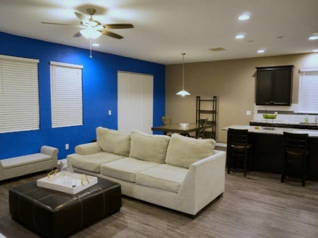 living room with ceiling fan, wood finished floors, and recessed lighting