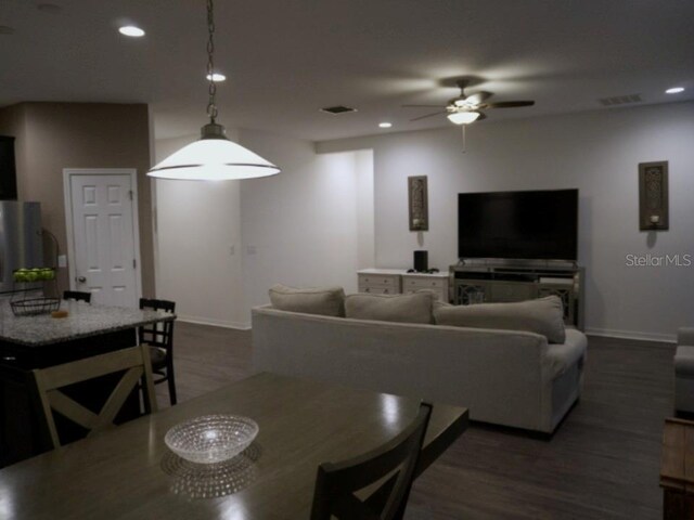 living area featuring ceiling fan, recessed lighting, dark wood-style flooring, visible vents, and baseboards