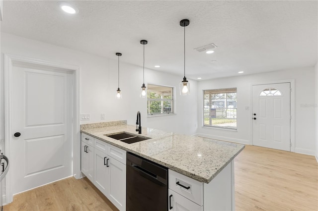 kitchen with visible vents, light wood-style flooring, a sink, dishwasher, and a peninsula