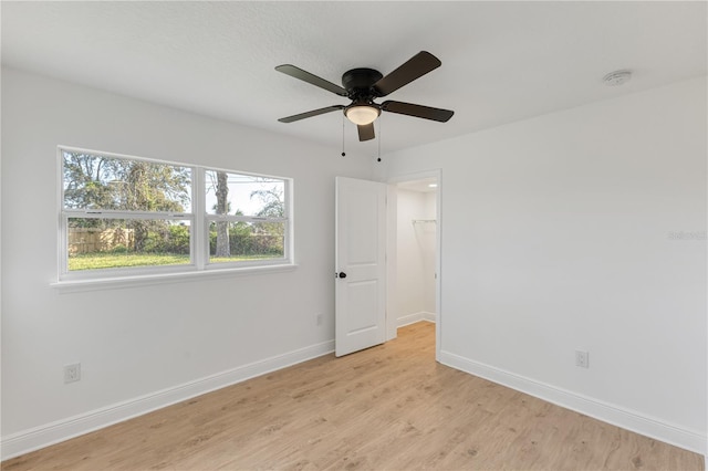 unfurnished bedroom featuring light wood-style floors, ceiling fan, and baseboards