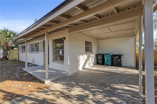 view of patio / terrace featuring a carport, fence, and driveway