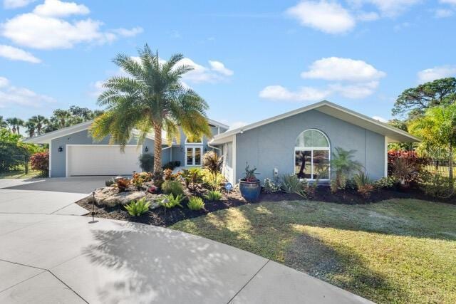 ranch-style home with a front lawn, concrete driveway, an attached garage, and stucco siding