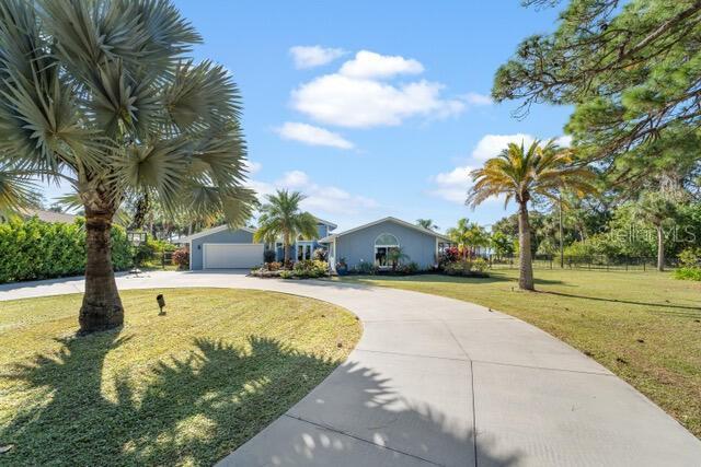 view of front of property with a garage, a front lawn, and concrete driveway