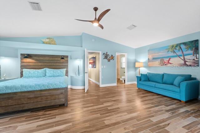 bedroom featuring lofted ceiling, ceiling fan, wood finished floors, visible vents, and baseboards