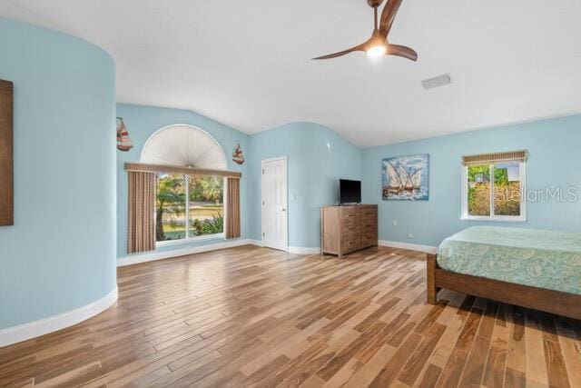 bedroom featuring vaulted ceiling, multiple windows, and wood finished floors