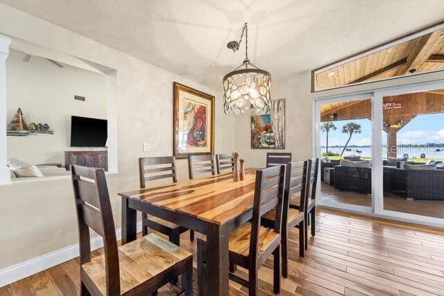 dining space with an inviting chandelier, baseboards, and hardwood / wood-style floors