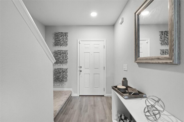 foyer featuring baseboards and wood finished floors