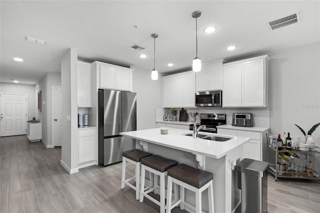 kitchen featuring visible vents, appliances with stainless steel finishes, light countertops, and a sink