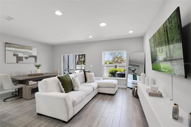 living area featuring recessed lighting, visible vents, baseboards, and wood finished floors