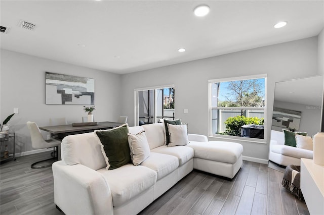 living area with visible vents, wood finished floors, and recessed lighting