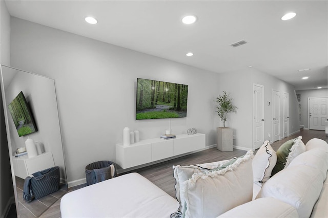 living area featuring recessed lighting, visible vents, baseboards, and wood finished floors