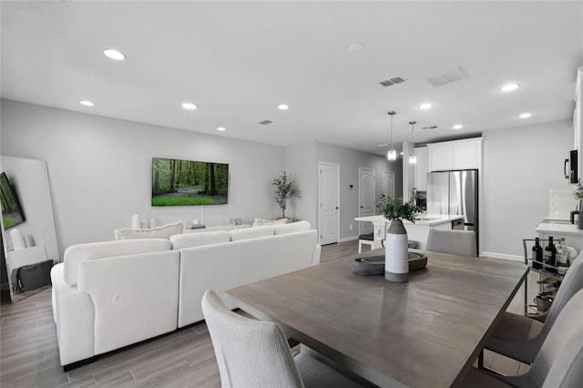 dining area with recessed lighting, baseboards, visible vents, and light wood finished floors