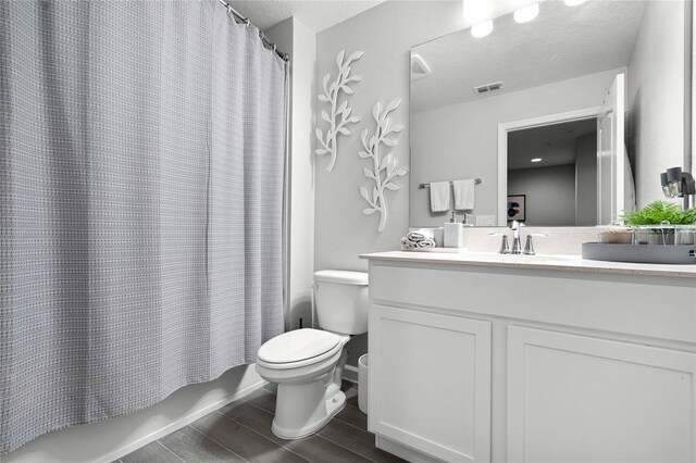 full bathroom with a textured ceiling, toilet, vanity, visible vents, and shower / bathtub combination with curtain