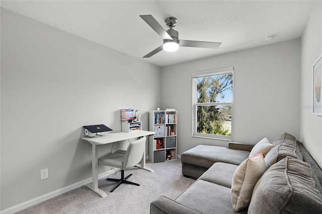 home office with light carpet, ceiling fan, and baseboards