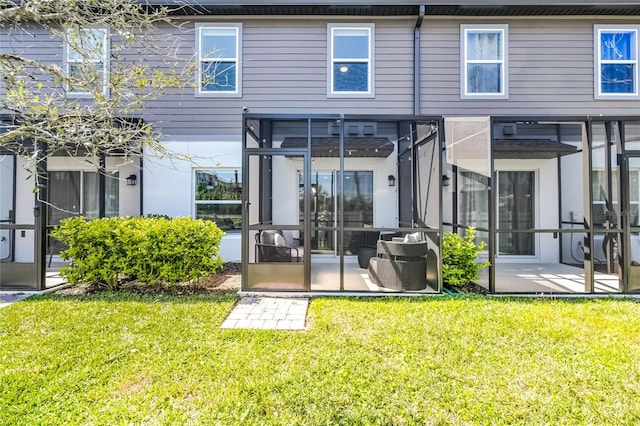 back of house with a yard and a sunroom