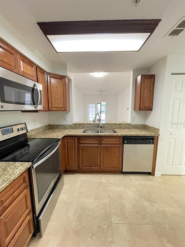 kitchen featuring visible vents, brown cabinets, appliances with stainless steel finishes, and a sink