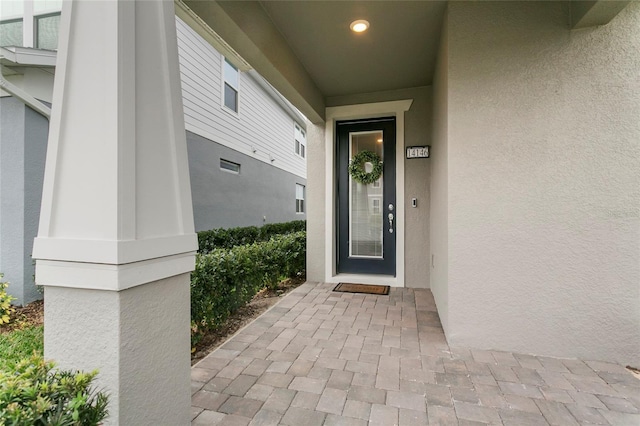 entrance to property featuring stucco siding