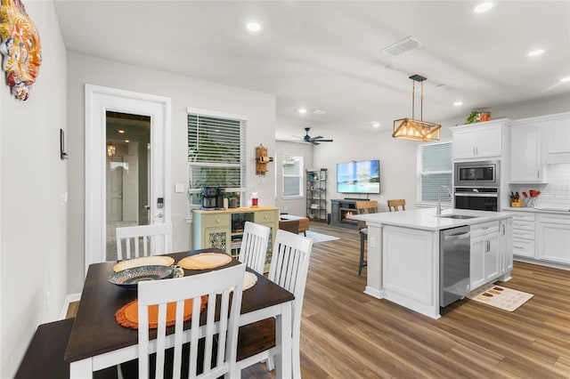 kitchen featuring stainless steel appliances, wood finished floors, visible vents, and white cabinetry