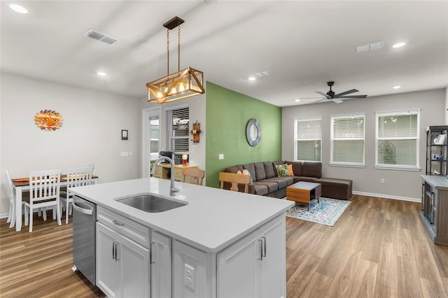 kitchen featuring light wood-style floors, visible vents, a sink, and dishwasher