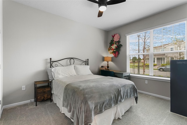 bedroom with a ceiling fan, baseboards, and carpet flooring