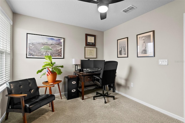 office space featuring carpet floors, visible vents, baseboards, and a ceiling fan