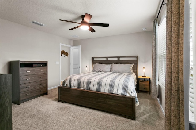 carpeted bedroom featuring visible vents, ceiling fan, a textured ceiling, and baseboards