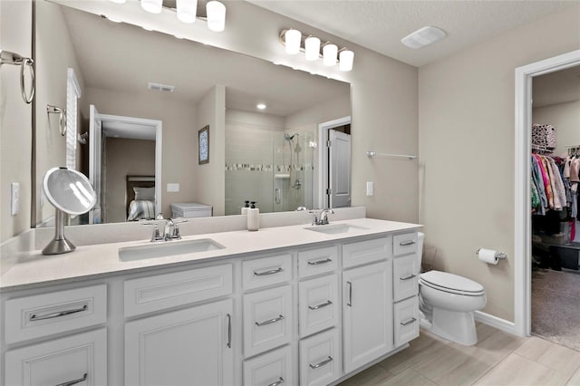 bathroom with toilet, a shower stall, visible vents, and a sink