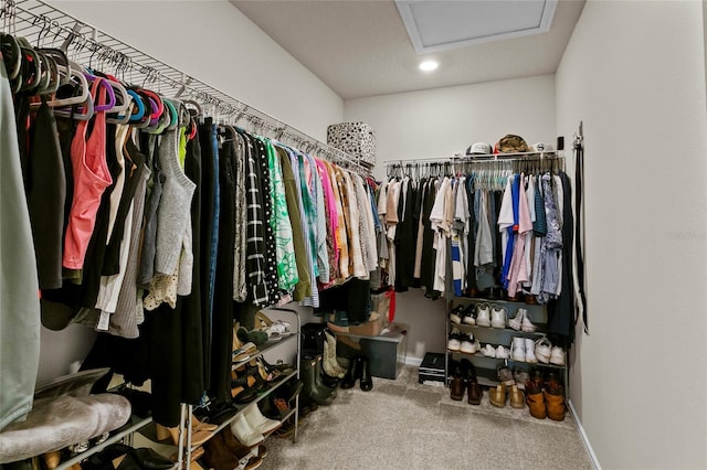 walk in closet with attic access and carpet floors