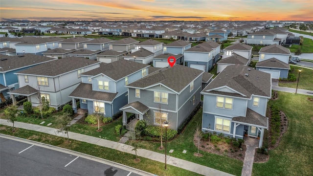 aerial view at dusk featuring a residential view